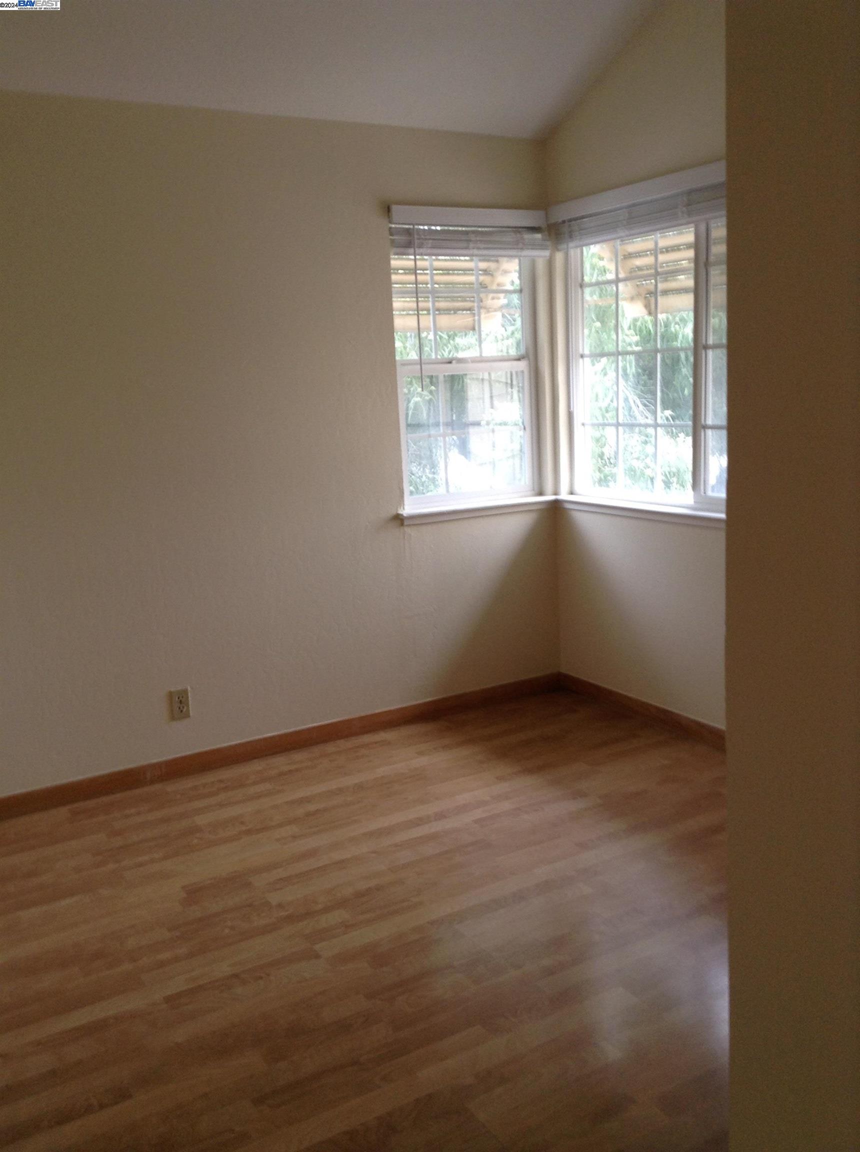 1064 Dempsey Road Milpitas, CA 95035 - Photo 19 of 31 an empty room with wooden floor and windows