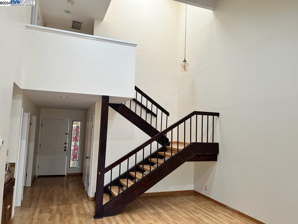 1064 Dempsey Road Milpitas, CA 95035 - Photo 8 of 31 a view of staircase with wooden floor and white walls