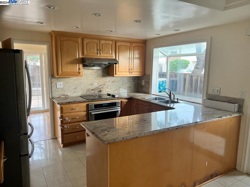 1064 Dempsey Road Milpitas, CA 95035 - Photo 9 of 31 a kitchen with stainless steel appliances granite countertop a sink a stove and a refrigerator