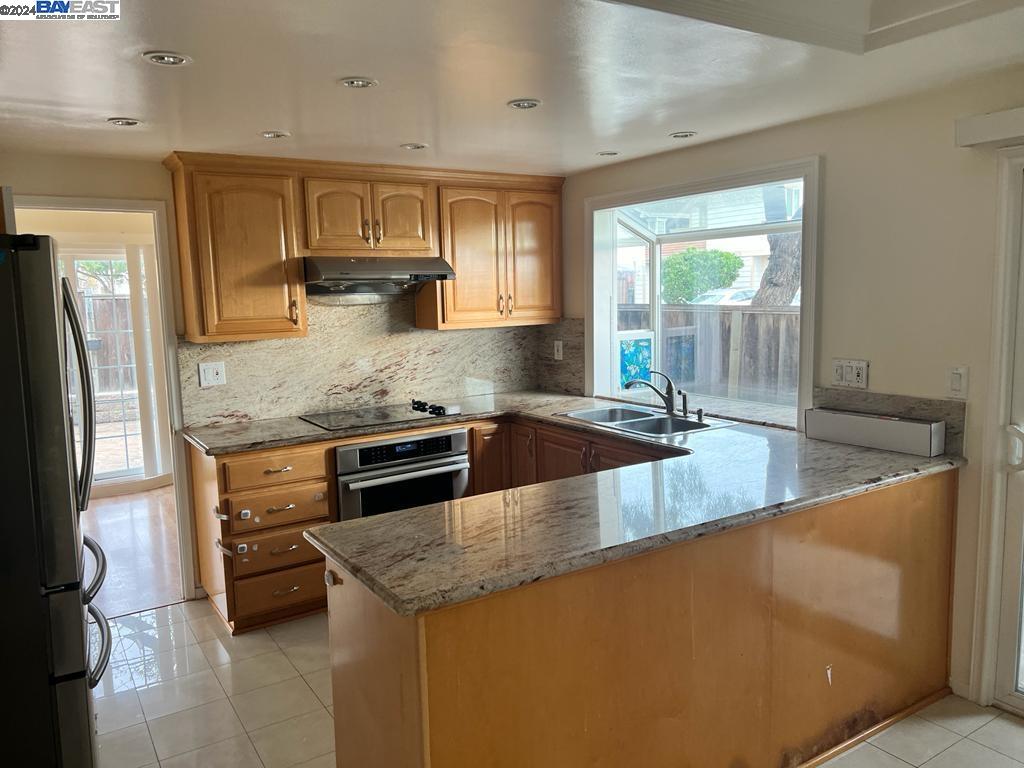 1064 Dempsey Road Milpitas, CA 95035 - Photo 10 of 31 a kitchen with stainless steel appliances granite countertop a sink a stove and a refrigerator