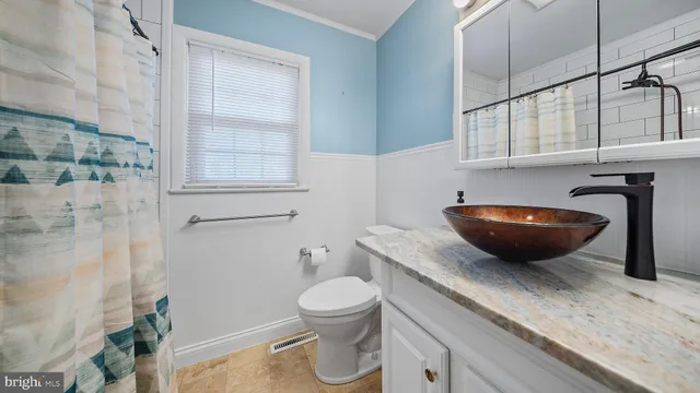 a bathroom with a granite countertop sink a toilet and a mirror