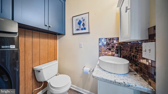 a bathroom with a granite countertop toilet sink and mirror