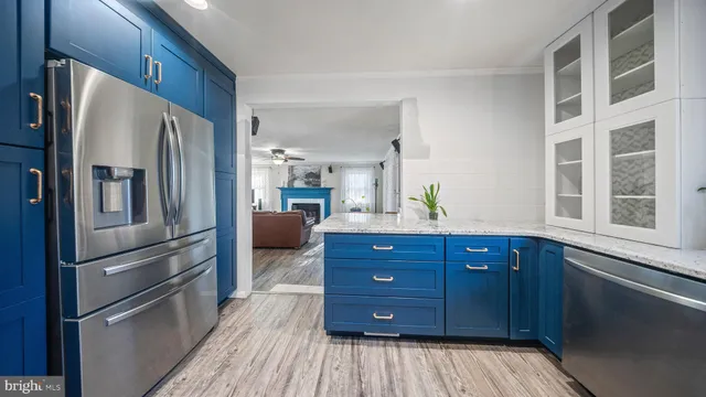 a kitchen with a refrigerator and wooden floor
