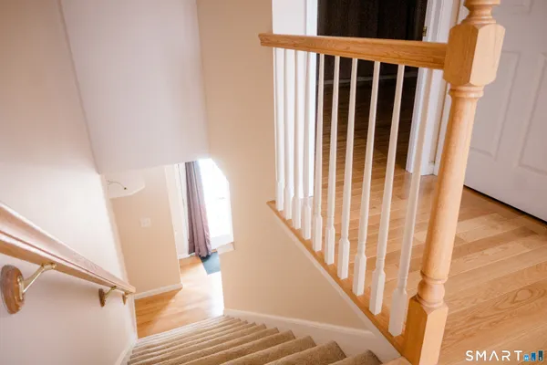 a view of staircase with railing and white walls