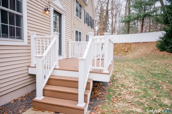 a front view of a house with wooden stairs and floor to ceiling windows