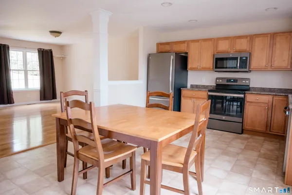 a kitchen with stainless steel appliances kitchen island a table and chairs