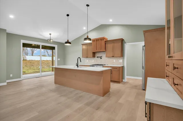 a large kitchen with kitchen island a sink stainless steel appliances and cabinets