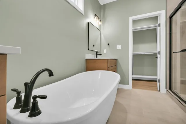a bathroom with a bathtub sink and mirror
