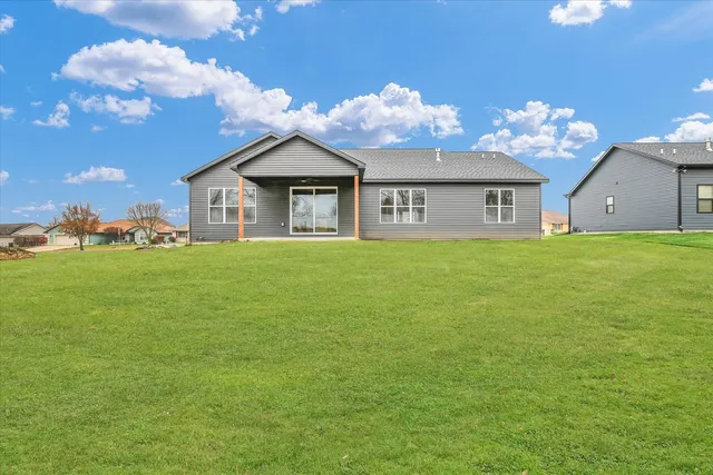 a view of a house with a big yard and large trees