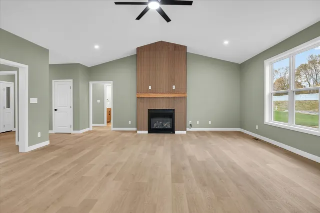 an empty room with windows and fireplace