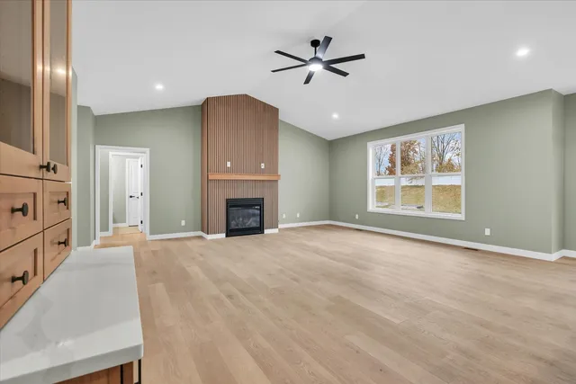 an empty room with windows and fireplace