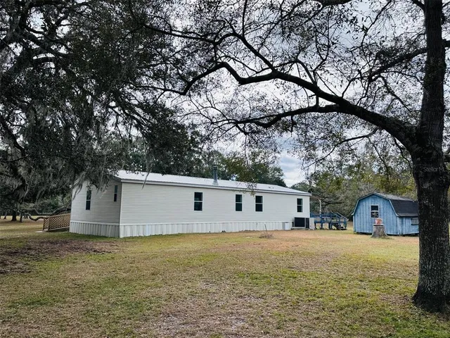 a view of a yard with large trees