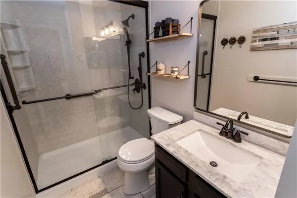 a bathroom with a sink a toilet a mirror and shower