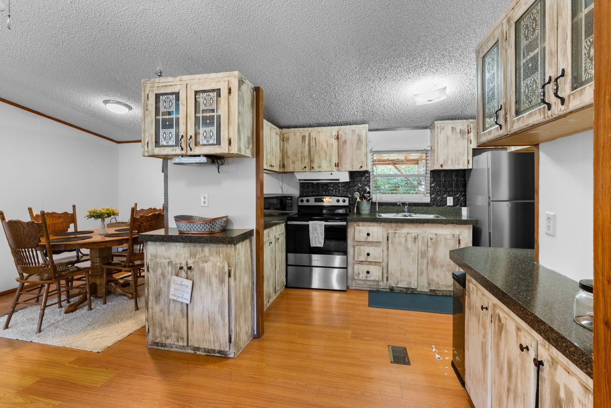 5147 Wiley Hollow Road Culleoka, TN 38451 - Photo 5 of 29 a kitchen with stainless steel appliances kitchen island granite countertop a refrigerator a stove top oven a sink dishwasher and white cabinets with wooden floor