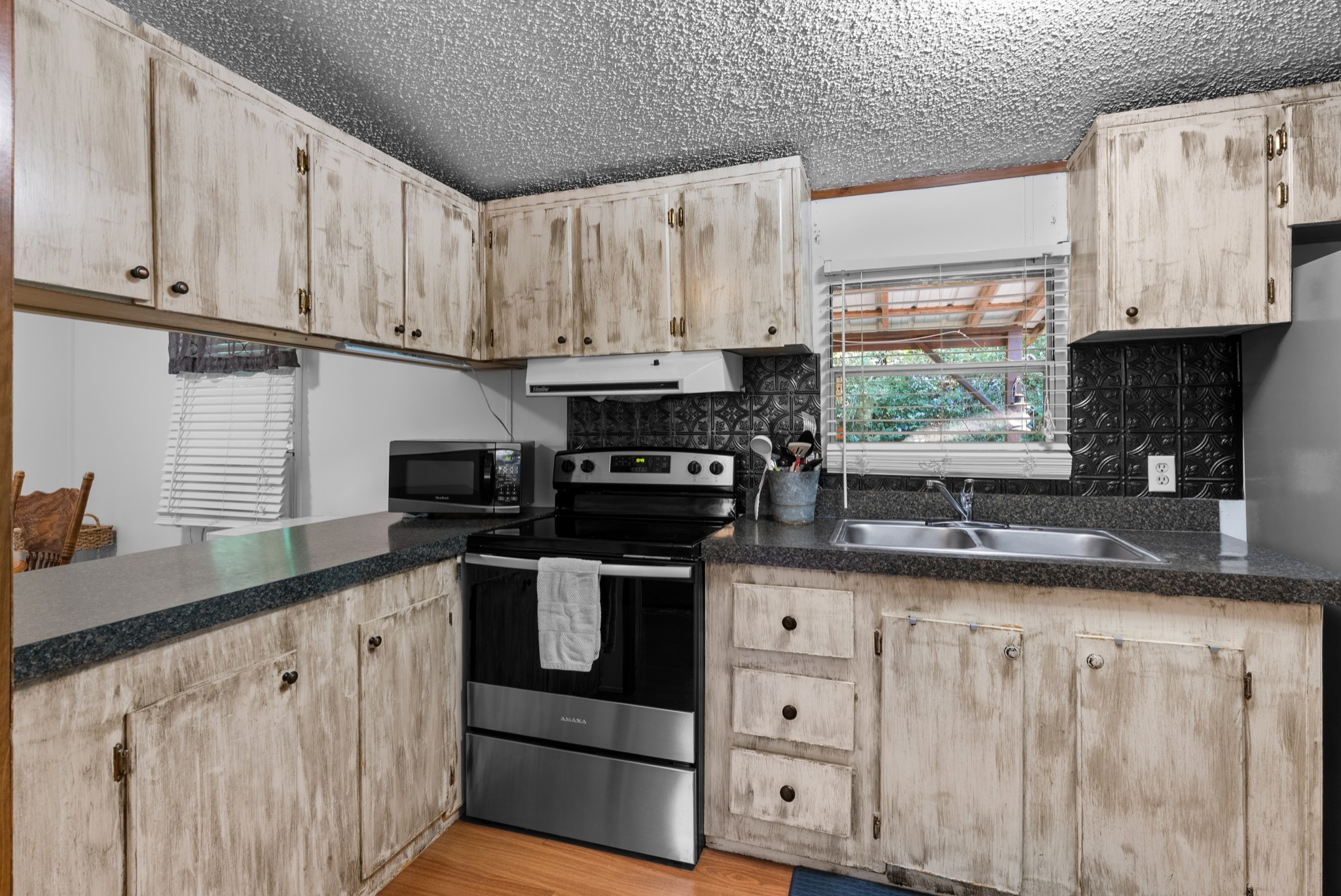 5147 Wiley Hollow Road Culleoka, TN 38451 - Photo 6 of 29 a kitchen with granite countertop white cabinets sink and stainless steel appliances