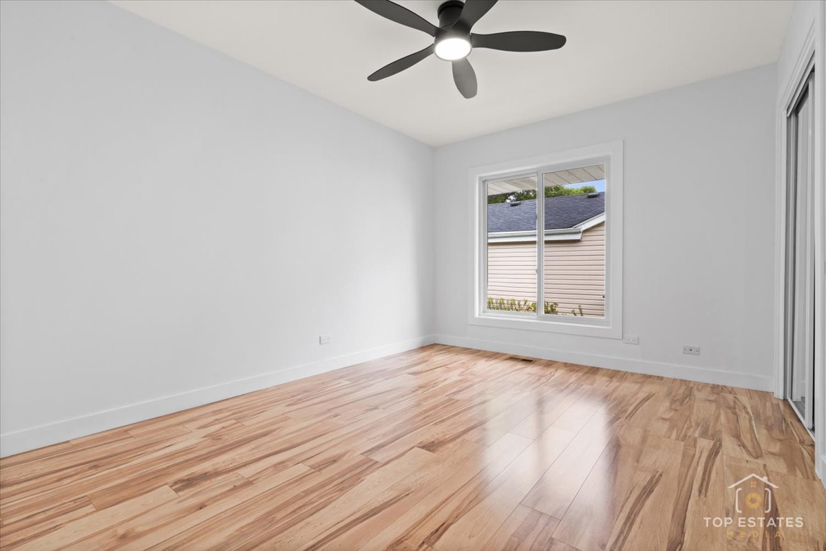 1327 Churchill Road Schaumburg, IL 60169 - Photo 49 of 71 a view of an empty room with wooden floor and a window