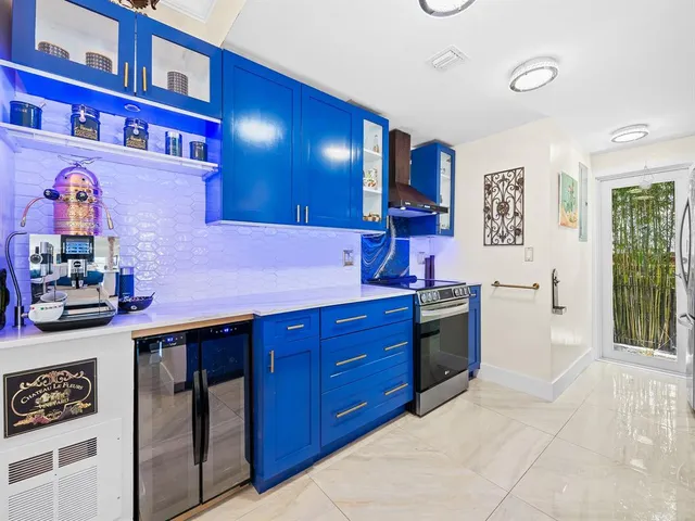 a kitchen with stainless steel appliances granite countertop a stove a sink and a refrigerator