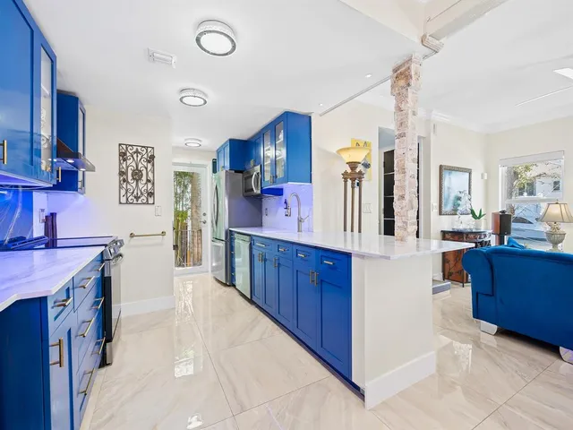 a kitchen with stainless steel appliances a stove top oven a refrigerator a sink and dishwasher