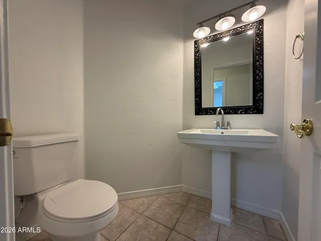 a bathroom with a sink a toilet and mirror