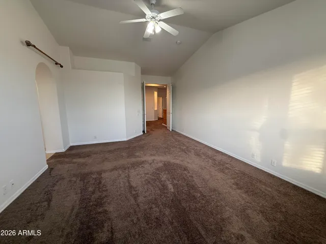 a view of a room with a ceiling fan and hardwood floor