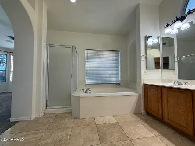 a spacious bathroom with a bathtub sink and mirror