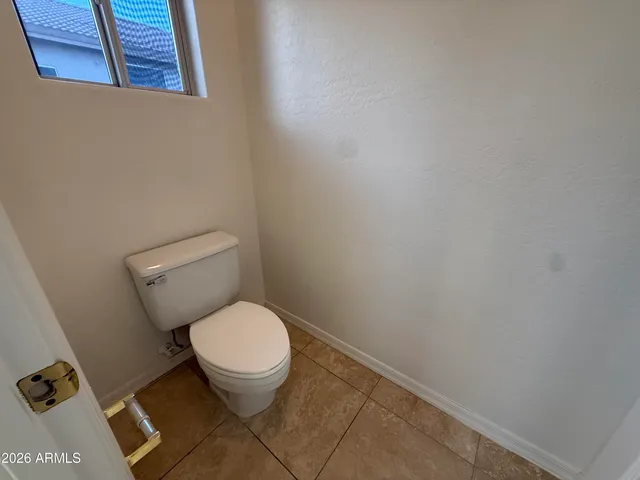 a white toilet sitting next to a white wall