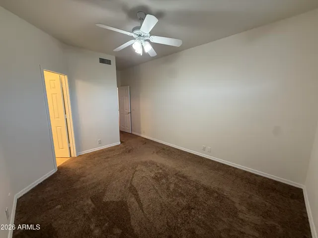 a view of a livingroom with a chandelier fan and a window