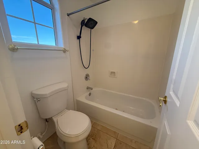 a white toilet sitting next to a bath tub