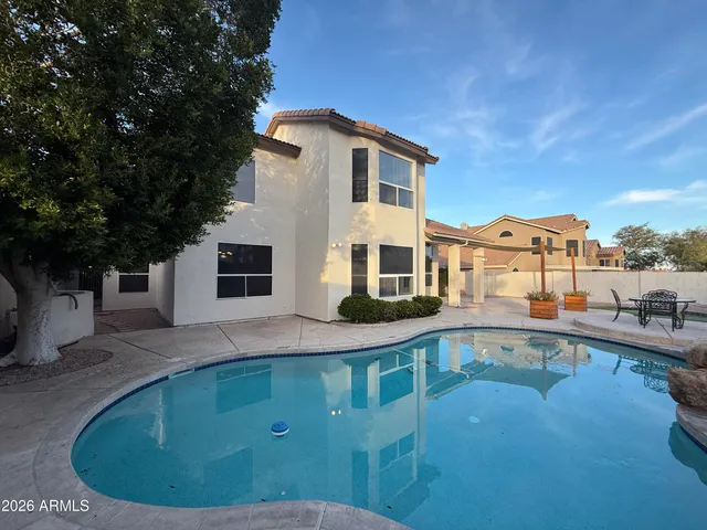 a view of a house with pool and chairs