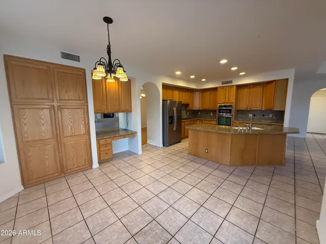 a view of kitchen with refrigerator cabinets and furniture