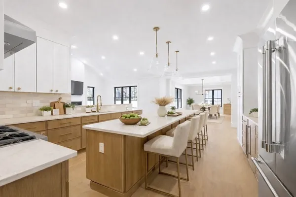 a kitchen with a sink a stove a refrigerator and white cabinets with wooden floor