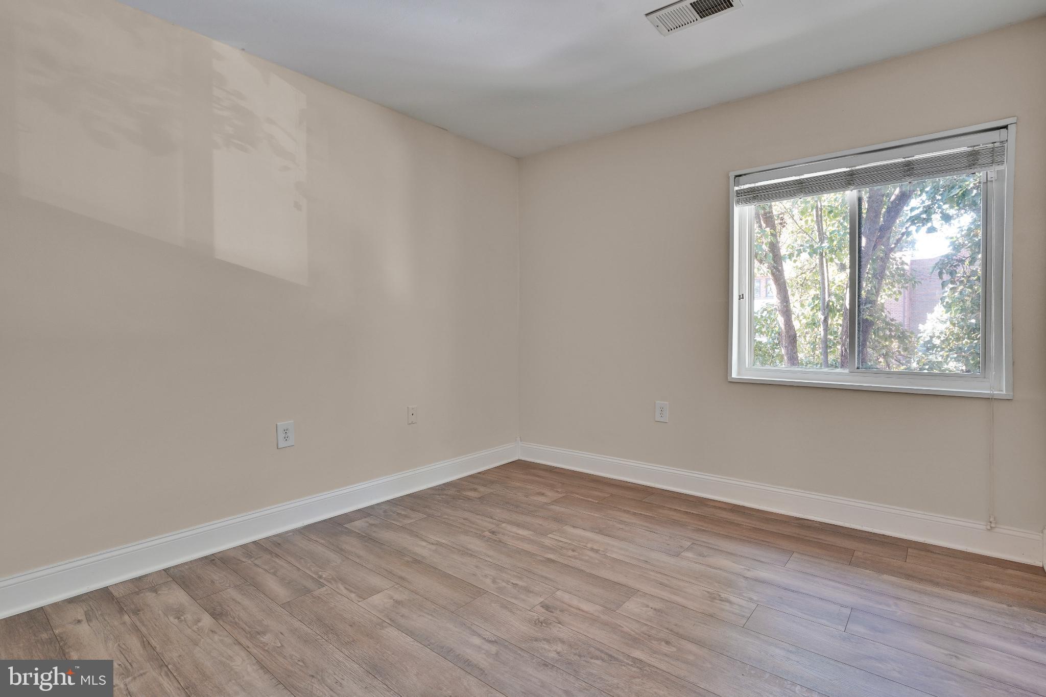 1439 Northgate Square, Unit 39/21B Reston, VA 20190 - Photo 20 of 23 a view of an empty room with wooden floor and a window