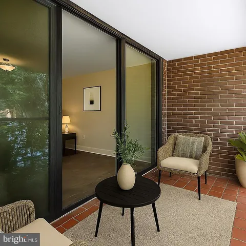 a view of a balcony with chairs and a potted plant