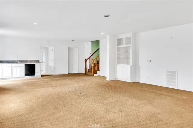 a view of a livingroom with wooden floor and a bathroom