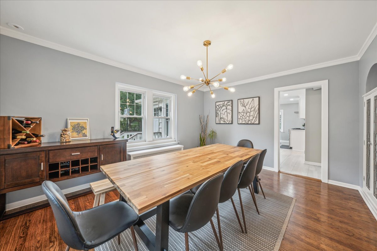 212 E Road Glen Ellyn, IL 60137 - Photo 13 of 42 a dining room with wooden floor a chandelier a wooden table and chairs