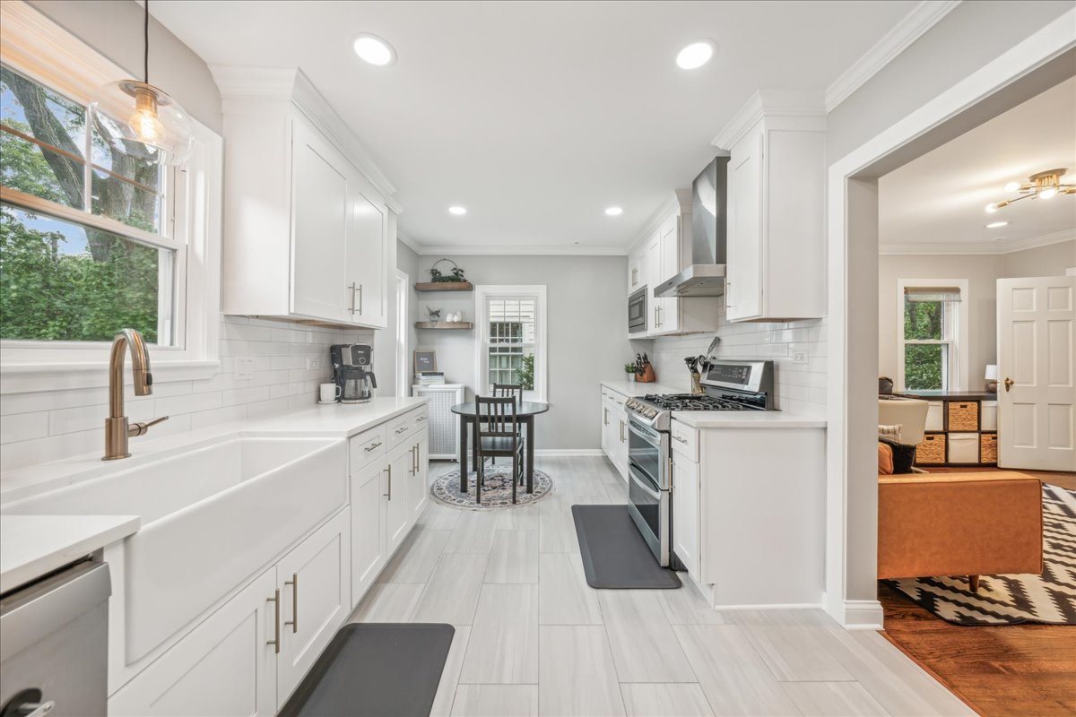 212 E Road Glen Ellyn, IL 60137 - Photo 6 of 42 an open kitchen with white cabinets and stainless steel appliances