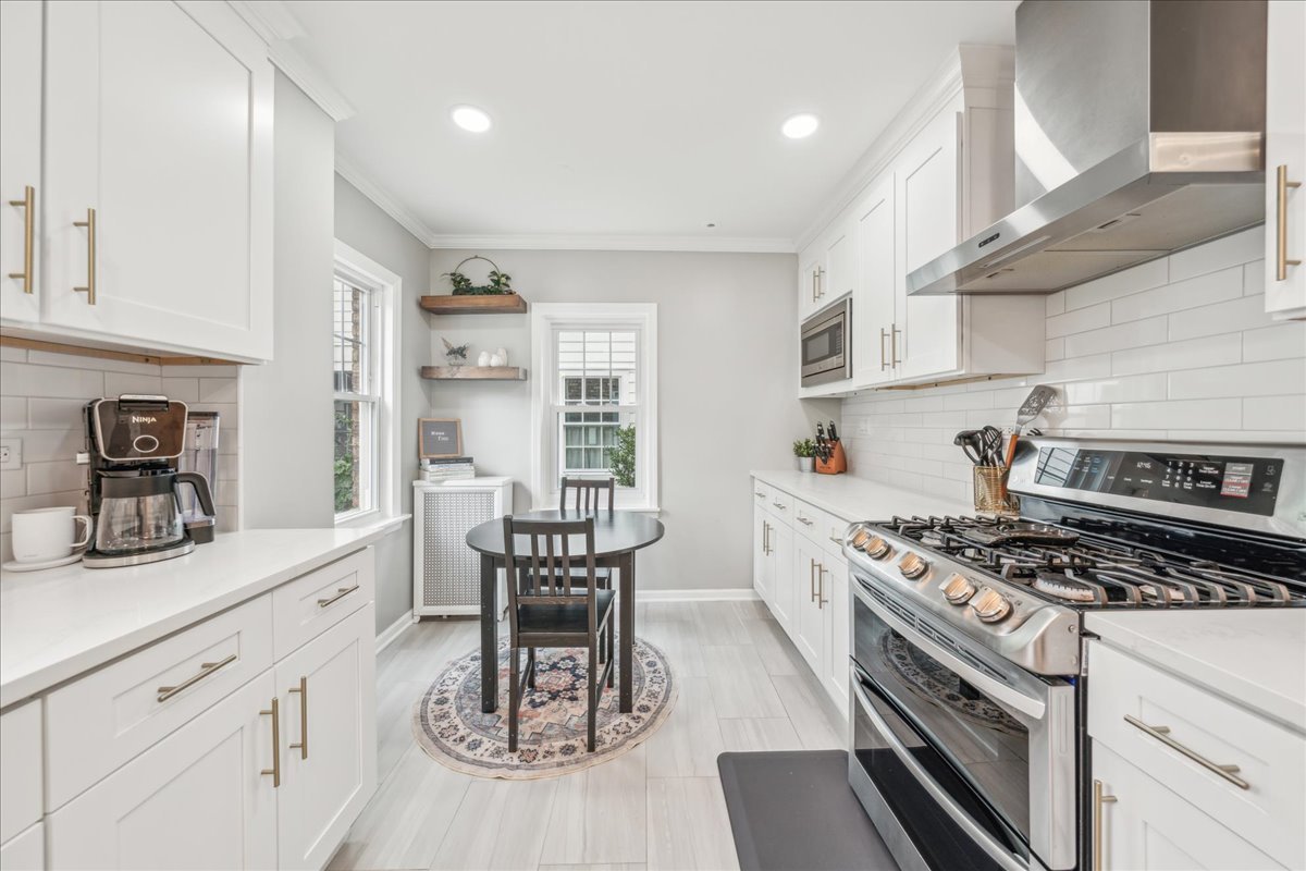 212 E Road Glen Ellyn, IL 60137 - Photo 8 of 42 a kitchen with stainless steel appliances granite countertop a stove a sink dishwasher and cabinets with wooden floor