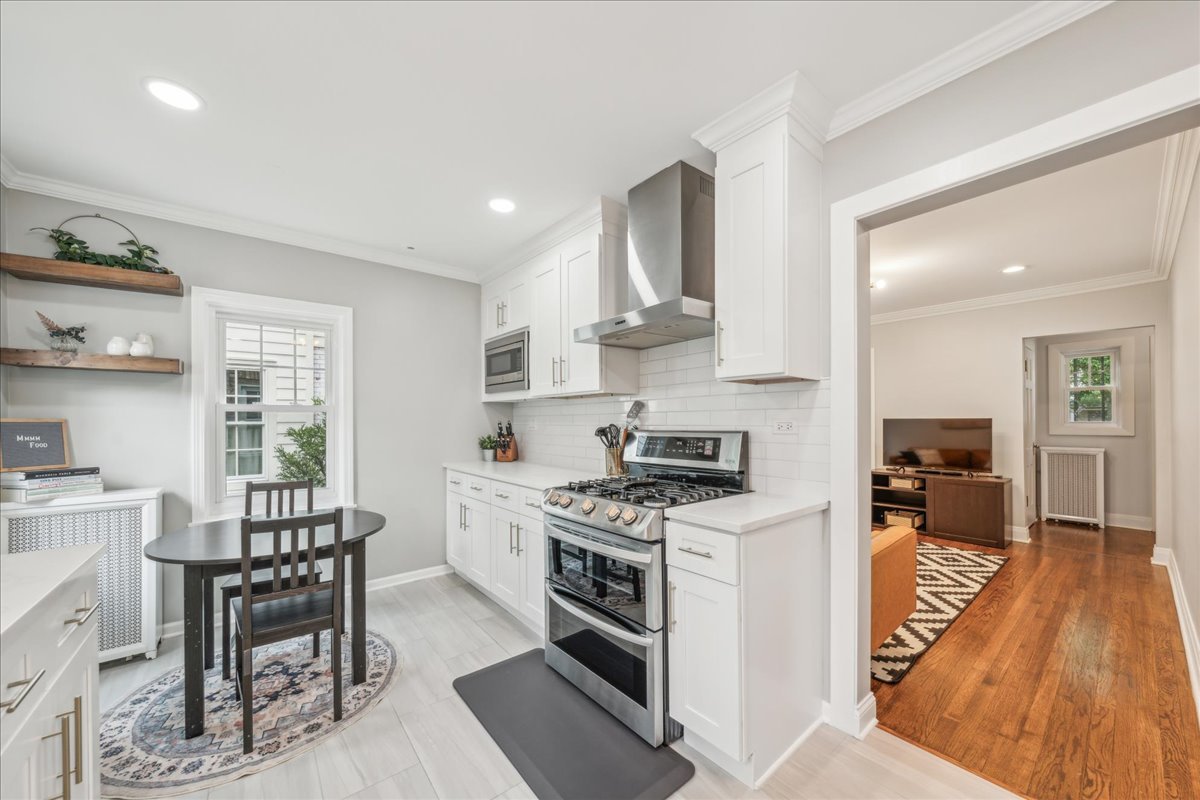 212 E Road Glen Ellyn, IL 60137 - Photo 9 of 42 a kitchen with stainless steel appliances a stove a sink dishwasher a refrigerator and a dining table with wooden floor