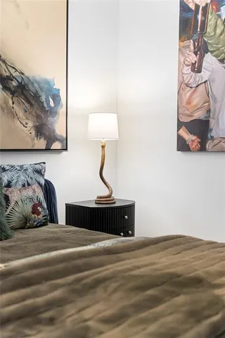 a bedroom with a bed and a painting on the wall