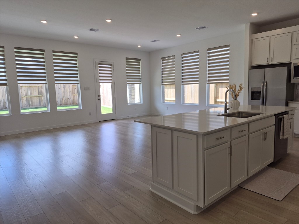 31007 Golden Felipe Street Fulshear, TX 77441 - Photo 5 of 19 a kitchen with stainless steel appliances granite countertop a sink a stove a refrigerator and a large window