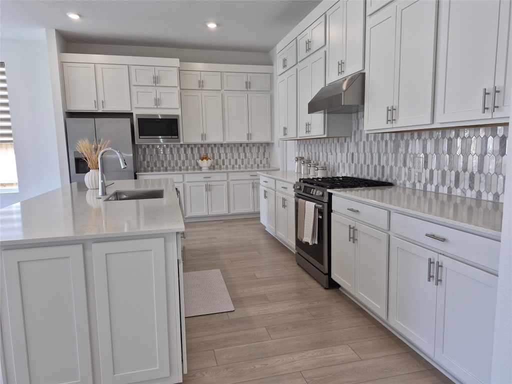 31007 Golden Felipe Street Fulshear, TX 77441 - Photo 7 of 19 a kitchen with granite countertop white cabinets and white appliances