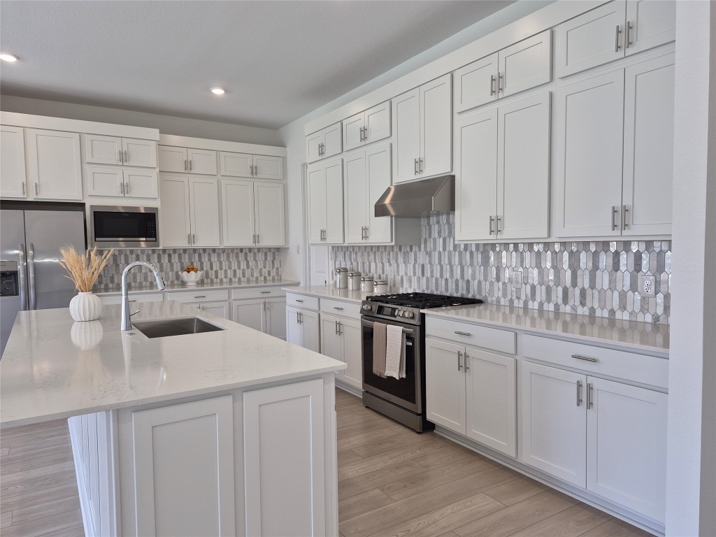 31007 Golden Felipe Street Fulshear, TX 77441 - Photo 8 of 19 a kitchen with white cabinets sink and appliances