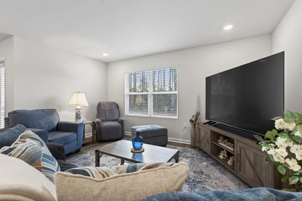 a view of a hallway with wooden floor and a bathroom
