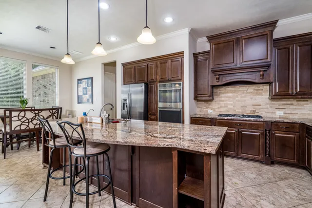 a kitchen with cabinets appliances and a dining table