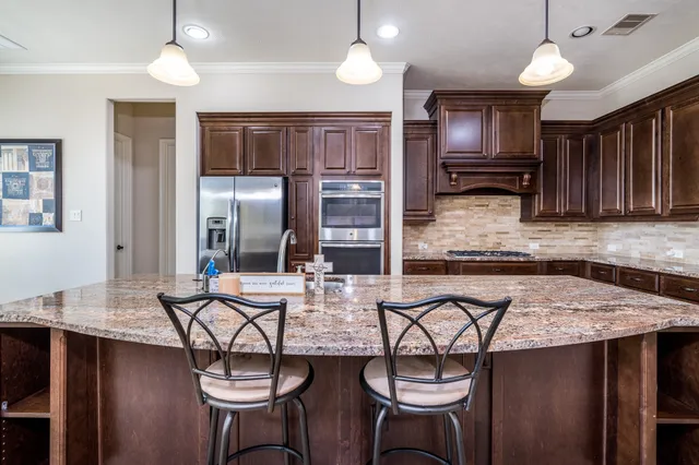 a kitchen with stainless steel appliances granite countertop a sink and a refrigerator