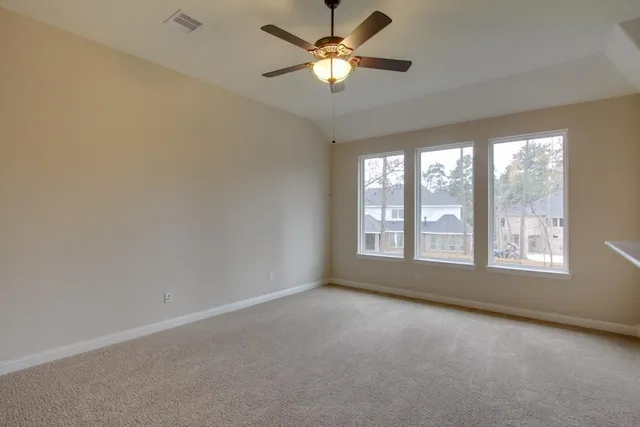 an empty room with a window and a fan