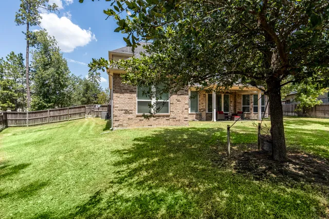 a view of a house with backyard and a tree