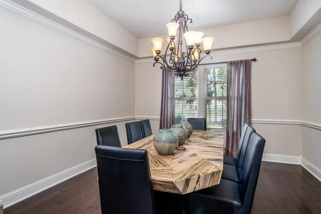 a view of a dining room with furniture a chandelier and wooden floor
