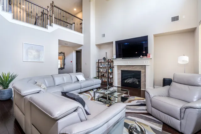 a living room with furniture a flat screen tv and a fireplace