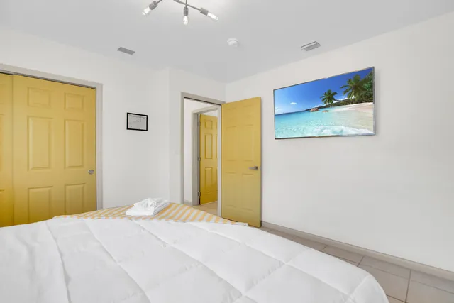 a bedroom with a large bed and a chandelier